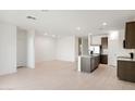 Open-concept living room featuring recessed lighting, tile floors, and an adjacent kitchen with island at 25356 W Sunland Ave, Buckeye, AZ 85326