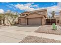 Two-story home featuring a terracotta tile roof, three-car garage, and low-maintenance desert landscaping at 3239 E San Manuel Rd, San Tan Valley, AZ 85143