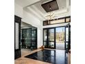 Open foyer with black marble floors, glass-enclosed wine display, and open doors framing the desert landscape at 41248 N 96Th St, Scottsdale, AZ 85262