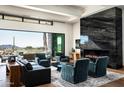 Open living room featuring a modern fireplace and large windows with stunning desert views at 41248 N 96Th St, Scottsdale, AZ 85262