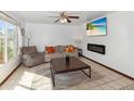 Bright living room with a ceiling fan, plush seating, modern fireplace, and a large window at 8410 N 32Nd Ave, Phoenix, AZ 85051