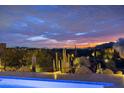 Beautiful backyard pool featuring a sunset view surrounded by desert landscape and cacti at 9602 E Taos Dr, Scottsdale, AZ 85262