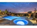 Inviting pool and hot tub area with desert landscaping illuminated at twilight at 9602 E Taos Dr, Scottsdale, AZ 85262