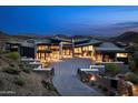 Modern estate with impressive stone accents, a paved driveway, and a landscaped desert setting at 9643 E Cintarosa Pass, Scottsdale, AZ 85262
