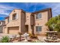 Two-story home displaying a two-car garage, desert landscaping, and an angel water fountain at 11856 W Grant St, Avondale, AZ 85323