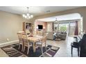 Open-concept living room with dining area featuring tile flooring and stylish decor at 15613 W Minnezona Ave, Goodyear, AZ 85395