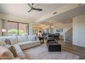 Bright, open-concept living room featuring a comfortable sofa, modern ceiling fan and seamlessly connects to the dining area at 16248 E Ridgeline Dr, Fountain Hills, AZ 85268