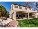 Green backyard with a covered patio, lush lawn, and desert landscaping at 16291 W Crenshaw Dr, Surprise, AZ 85379