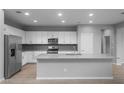 Bright, updated kitchen with white cabinets, stainless steel appliances, and a gray backsplash at 17812 W Getty Dr, Goodyear, AZ 85338