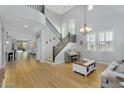 Bright living room with a staircase, hardwood floors, large windows, and a grand chandelier at 1961 E Stacey Rd, Gilbert, AZ 85298