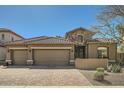 Charming home showcasing a three-car garage, stone accents and desert landscaping at 2059 W Whisper Rock Trl, Phoenix, AZ 85085