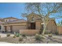 Beautiful home exterior featuring a three-car garage, stone accents and desert landscaping at 2059 W Whisper Rock Trl, Phoenix, AZ 85085