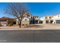 Charming two-story home with a well-manicured lawn and a tree in the front yard at 22302 E Camina Plata --, Queen Creek, AZ 85142