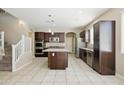 Bright kitchen featuring a large island, stainless steel appliances, and adjacent staircase at 22302 E Camina Plata --, Queen Creek, AZ 85142
