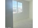 A bedroom with a large window and white walls provides natural light at 2416 E Spur Dr, San Tan Valley, AZ 85140