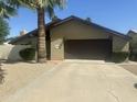 View of single-story house featuring desert landscaping, a spacious driveway, and a two car garage at 2644 E Sylvia St, Phoenix, AZ 85032