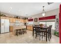 Bright kitchen boasts wooden cabinetry, tiled floors, island with seating, and adjacent dining area at 2656 E Longhorn Pl, Chandler, AZ 85286