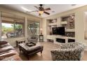 Cozy living room with large windows, built-in shelving, and comfortable seating at 26735 N 127Th Dr, Peoria, AZ 85383