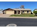 Single level home with a two-car garage and green front lawn under a blue sky at 3502 E El Moro Ave, Mesa, AZ 85204