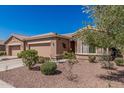 Attractive front exterior with well-maintained landscaping, a three-car garage and inviting curb appeal at 41960 W Ellington Ln, Maricopa, AZ 85138