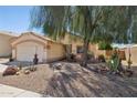 Landscaped front yard featuring a mature tree and xeriscape at 5867 W Cochise Dr, Glendale, AZ 85302