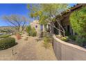 Expansive front yard featuring desert landscaping with a walkway leading up to an earth tone colored home at 7373 E Clubhouse Dr # 24, Scottsdale, AZ 85266