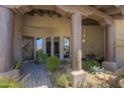 Front porch features desert landscaping, wood columns, and a table with chairs creating a welcoming entryway at 7373 E Clubhouse Dr # 24, Scottsdale, AZ 85266
