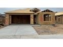 New home under construction, showcasing the framing and concrete driveway in a developing neighborhood at 7422 W Buckhorn Trl, Peoria, AZ 85383