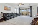 Spacious living room with plush carpeting, a ceiling fan, and sliding glass doors to the patio at 786 W Palo Verde W Dr, Casa Grande, AZ 85122