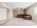 Spacious living room offers neutral carpet, ceiling fan, and a comfortable sectional sofa at 8155 E Roosevelt St # 204, Scottsdale, AZ 85257