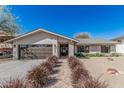 Charming single-story home with neutral stucco, desert landscaping, and a welcoming brick pathway to the front door at 8238 E San Miguel Ave, Scottsdale, AZ 85250