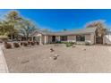Spacious single-story home with desert landscaping, including gravel and flowering plants, under a bright blue sky at 8238 E San Miguel Ave, Scottsdale, AZ 85250
