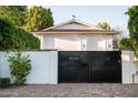 View of a black metal gate that secures the property, framed by a white wall at 8602 E Gary Rd, Scottsdale, AZ 85260