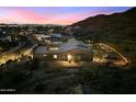Dusk aerial view of the property, with views of the surrounding desert landscape and city lights at 9539 S 13Th Way, Phoenix, AZ 85042