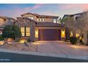 Elegant two-story home with stone accents, a well-manicured yard, and a spacious driveway at 9929 E South Bend Dr, Scottsdale, AZ 85255