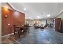 Open-concept living room featuring slate floors, leather furniture, wood built ins and a fireplace, ideal for entertaining at 14442 W Lexington Ave, Goodyear, AZ 85395