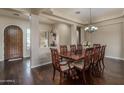 Elegant dining room featuring hardwood floors, decorative chandelier and a large wooden table with seating for eight at 1712 W Aloe Vera Dr, Phoenix, AZ 85085