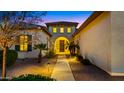 Inviting front entrance with a well-lit walkway, lush landscaping, and a charming courtyard perfect for evening strolls at 17755 E Colt Dr, Queen Creek, AZ 85142