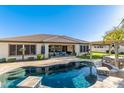 Beautiful backyard featuring a sparkling pool, covered patio, and lush landscaping at 19888 E Russet Rd, Queen Creek, AZ 85142