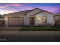 Charming single-story home with tile roof, arched entryway and manicured lawn, lit by outdoor lights at 2887 W Chevelon Dr, Queen Creek, AZ 85144