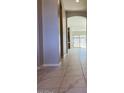 Bright hallway featuring tile floors, neutral wall paint, and an arched entryway leading to living area at 2887 W Chevelon Dr, Queen Creek, AZ 85144