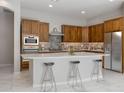 Modern kitchen featuring sleek white quartz countertops, dark wood cabinets, and stainless steel appliances at 2887 W Chevelon Dr, Queen Creek, AZ 85144