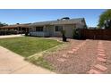 Cozy home featuring a lush lawn, a covered porch, and charming landscaping, creating inviting curb appeal at 332 N 25Th St, Mesa, AZ 85213