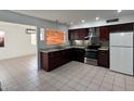 Bright kitchen featuring stainless steel appliances, granite countertops, dark wood cabinets, and tile floors at 332 N 25Th St, Mesa, AZ 85213