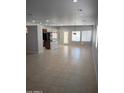 Open living room with tile flooring, recessed lighting, and ample natural light, perfect for comfortable living and entertaining at 37180 W Mondragone Ln, Maricopa, AZ 85138