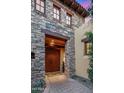 Elegant home entrance featuring a stone facade, wooden beams, and a beautiful double door at 42171 N Saguaro Forest Dr, Scottsdale, AZ 85262