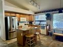 Kitchen with stainless steel refrigerator, wooden cabinets, center island, tile floor, and eat in dining area at 4643 E Cherry Hills Dr, Chandler, AZ 85249