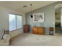 Living room featuring a large window, a gray accent wall, a modern pendant light, and neutral carpet at 4643 E Cherry Hills Dr, Chandler, AZ 85249