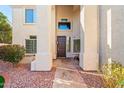 Inviting front entrance with stone walkway, pillars, desert landscaping, and cozy front porch at 5291 W Angela Dr, Glendale, AZ 85308