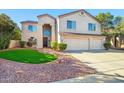 Stunning two-story home with a three-car garage, well-manicured lawn, and desert landscaping at 5291 W Angela Dr, Glendale, AZ 85308